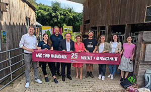 Neun beteiligte Personen halten das Schriftband "Wir sind Naturpark - Vielfalt und Gemeinsamkeit"
