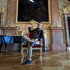 Schloss Rastatt, ein Schlossführer sitzt gelangweilt in einem barocken Saal auf einem Stuhl